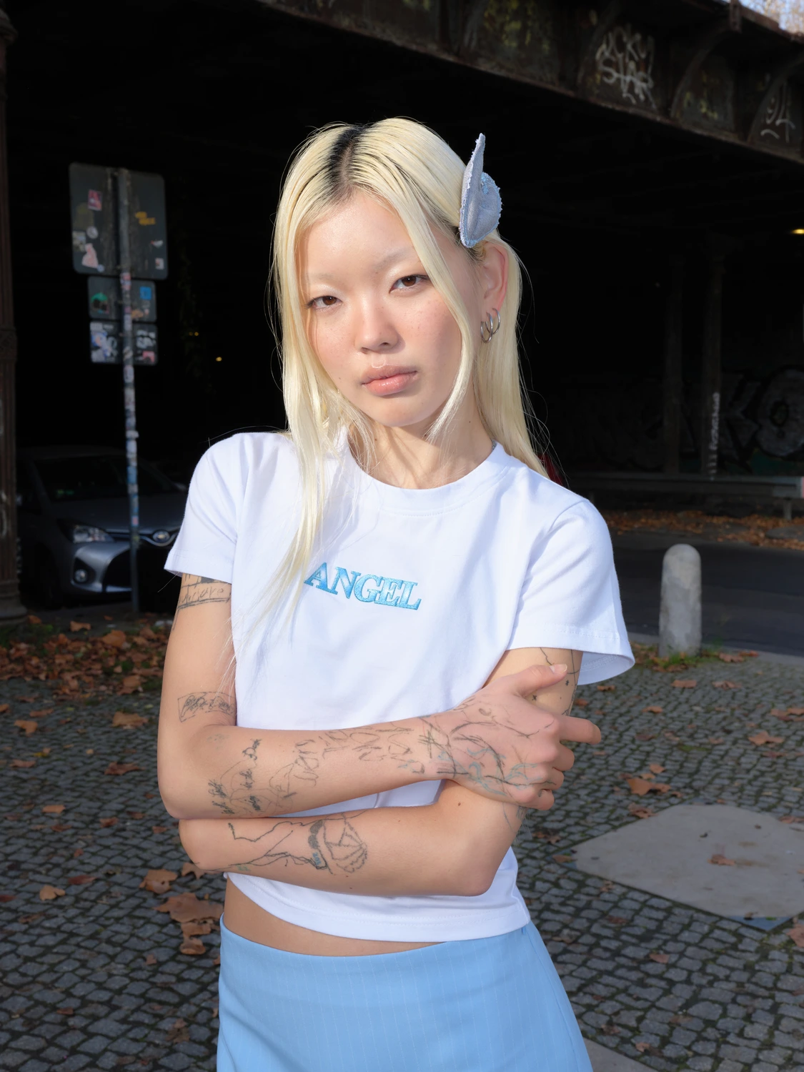 Model wearing white Angel t-shirt with light blue handcrafted hair clip shaped like a wing
