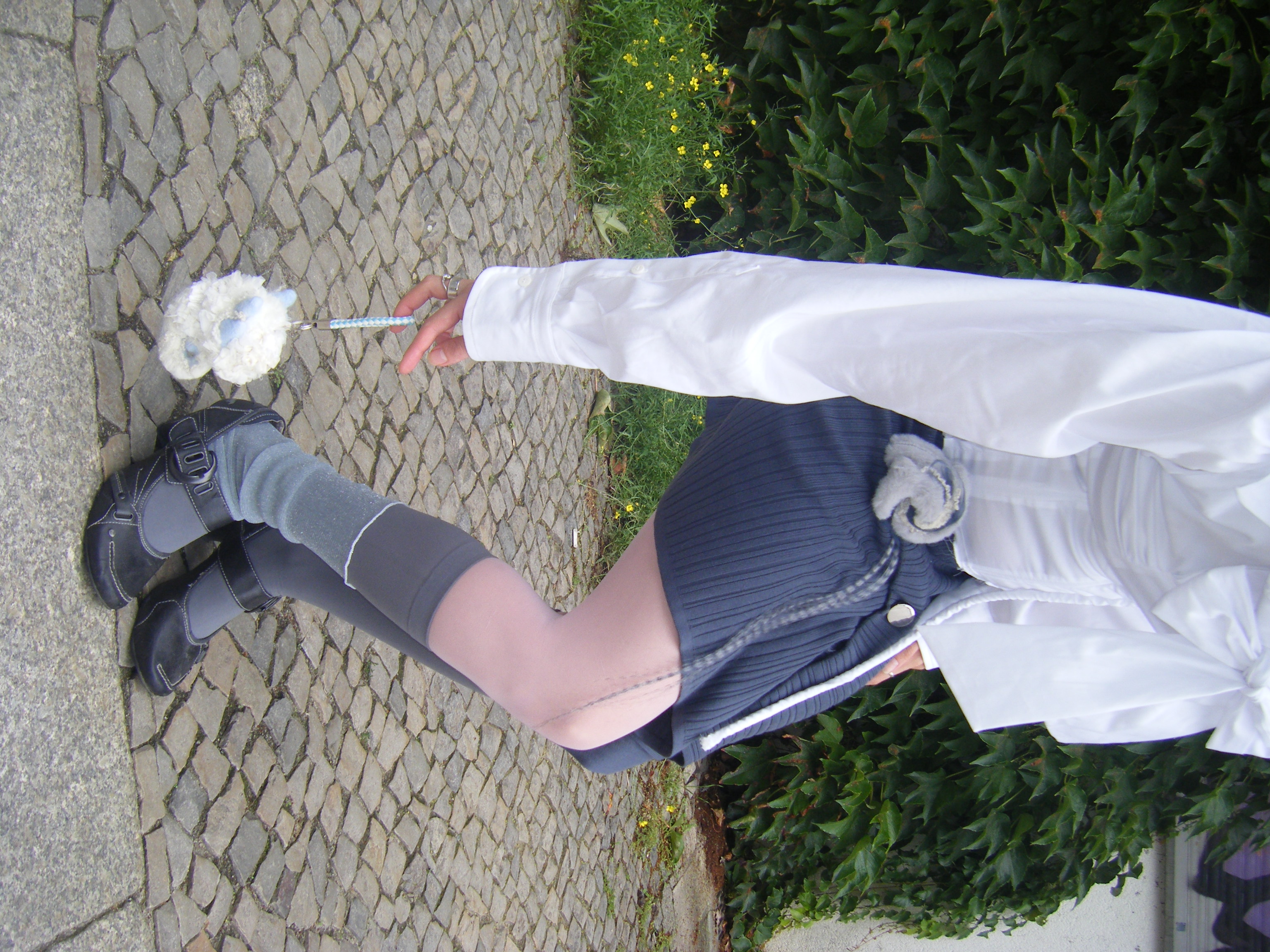 Person lying on fluffy white rug embracing soft mint and grey creature sculpture