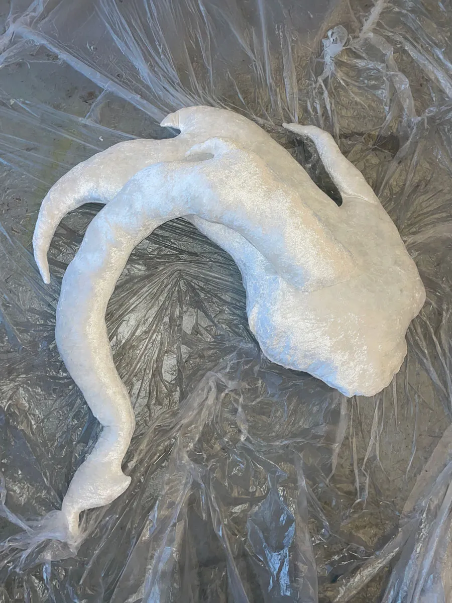 Large-scale soft sculptural installation with undulating mint green and grey forms for lying down