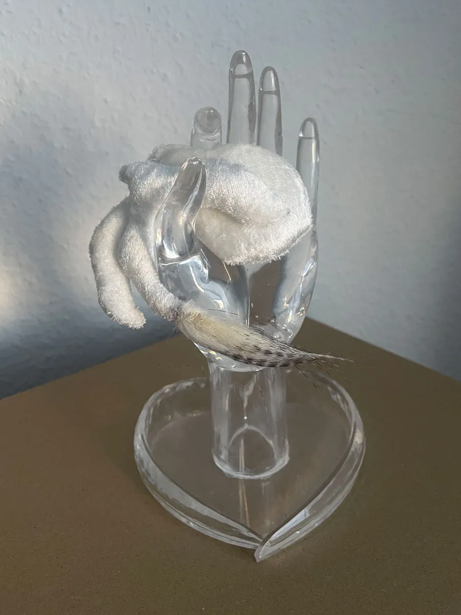 Miniature nubi cloud creature as wearable brooch amulet in soft pale tones